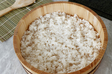 Sushi rice in traditional wooden bowl. Preparing homemade sushi.
