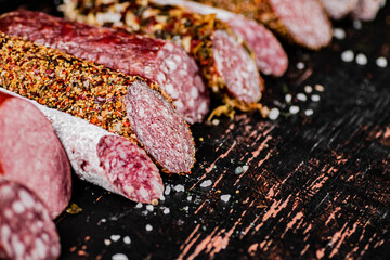 Various salami sausage on the table in a row. 