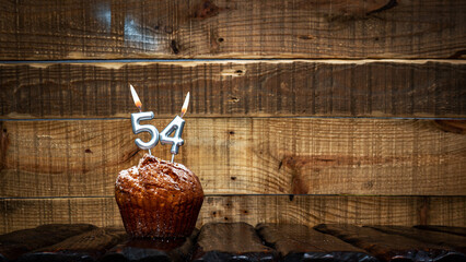 Background happy birthday pie or muffin with candles burning digit number  54. Festive card Happy...
