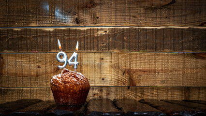 Background happy birthday pie or muffin with candles burning digit number  94. Festive card Happy...