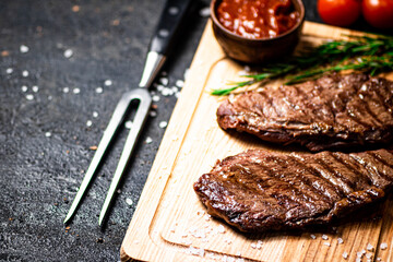 Grill steak on a wooden cutting board.