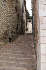 Old narrow alley with many stairs in Assisi, Umbria Italy