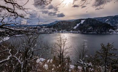 Glimpse of Lake Bled from the climb towards the castle. Winter day with snow.