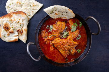 Traditional spicy Indian chicken Madras curry Rogan Josh with drumsticks, wings and garlic chapati...