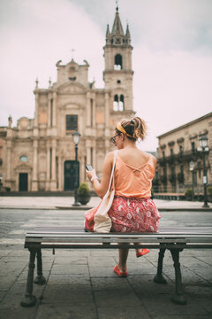 Tourist Girl Cheking Smart Phone While Sitting On Bus Station 