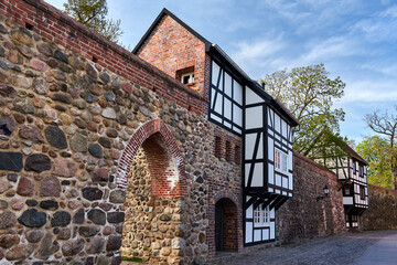 Fototapeta na wymiar Stone, medieval walls with a historic, multi -story house in the city of Neubrandenburg