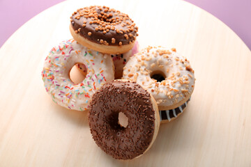 Wooden board with sweet donuts, closeup
