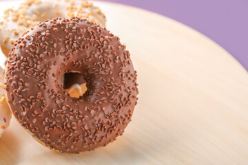 Wooden board with sweet donuts, closeup