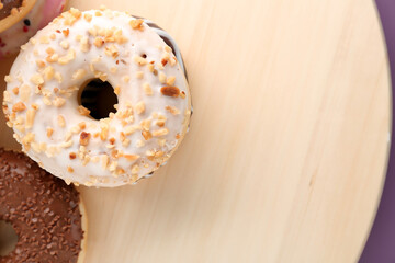 Wooden board with sweet donuts, closeup