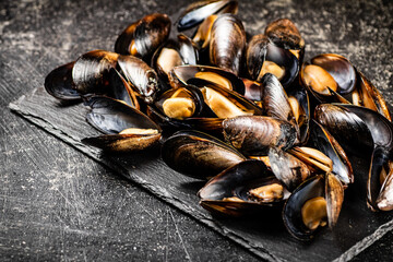 Delicious mussels on a stone board. 