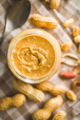 Peanut butter in jar on kitchen table. Top view.