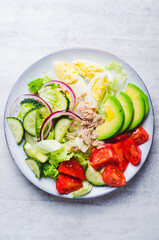 Tuna Salad, Healthy Food, Fresh Salad with Lettuce, Avocado, Cherries, Cucumber and Eggs on a Plate on Bright Background