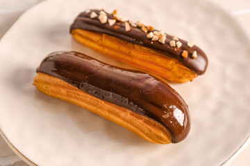 Plate of delicious chocolate eclairs, closeup