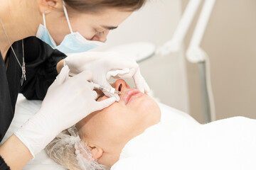 Obraz na płótnie Canvas Doctor cosmetologist doing the procedure Lip Augmentation
