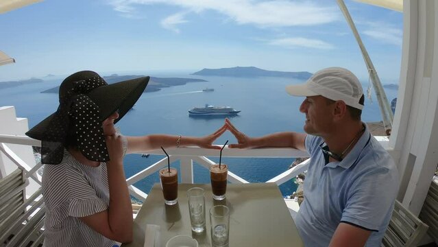 Couple having dinner on the background of the sea in Santorini, greece