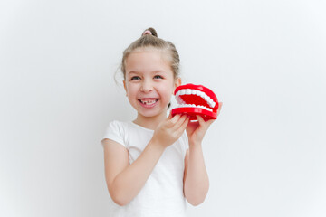 Cute happy caucasian toddler girl playing  with dentist. Medical stomatology. Dental, oral care,healthcare concept. White background.