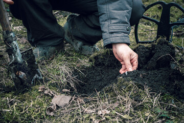 Finding old coins with a metal detector. The man dug up an antique coin. Fortuna during the instrumental search for antiquities.