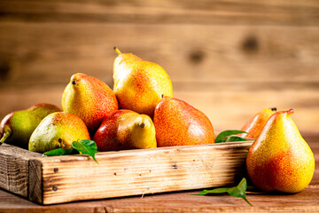 Fresh pears on a tray with leaves. 