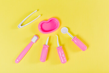 Children's dentist set. Yellow background. Flat lay. Medical, stomatology, kids toys concept. .