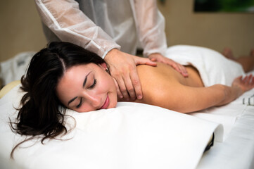 Obraz na płótnie Canvas Relaxed woman receiving a massage in a spa