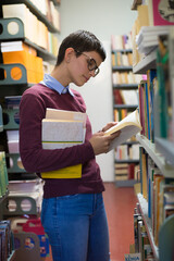 Young woman student reading books and studying in the library