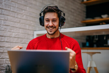 Cyber player celebrating online tournament victory from home. Excited man making yes gesture enjoying triumph. Overjoyed gamer winning in shooter battle in the headset. Happy blogger gaming influencer © La Famiglia