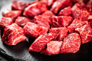 Pieces of raw beef on a stone board. 