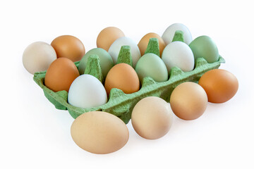 Eggs with different shell colors in a cardboard package on a white background