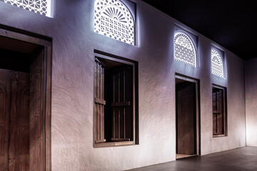 Arabic style window portals and carved wooden doors with arabesque ornaments, traditional Arabic architecture with modern illuminations, Dubai, United Arab Emirates.
