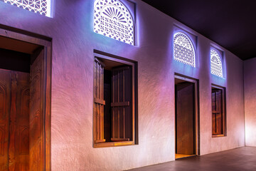 Arabic style window portals and carved wooden doors with arabesque ornaments, traditional Arabic architecture with modern illuminations, Dubai.