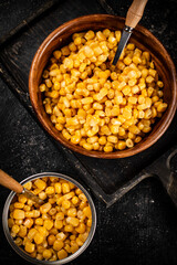 Canned corn on a wooden plate.