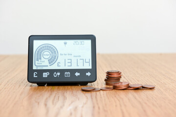 Smart meter and coins to represent cost of fuel and electricity for household bills