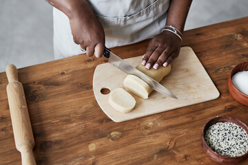 Of black woman baking homemade pastry on dark wood kitchen counter