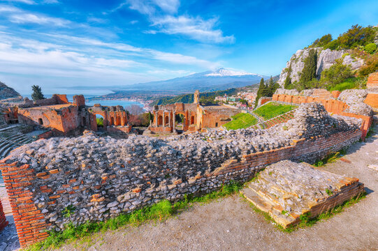 Ruins of ancient Greek theater in Taormina and Etna volcano in the backgroun