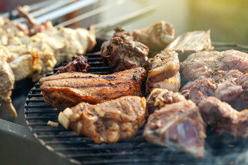 Cooking different meat on barbecue. Grilled and roasted lamb steaks on bbq