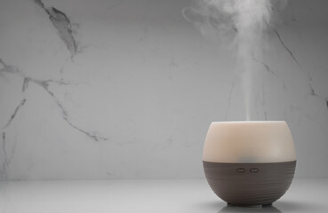Ultrasonic diffuser misting essential oils for cleaning air at home. Aromatherapy and alternative...