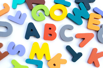 Colorful wooden alphabets on white background.