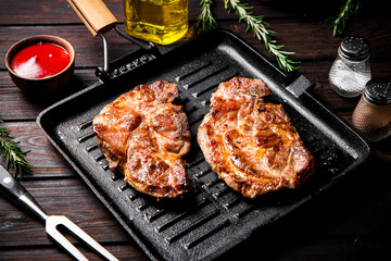 Grilled pork steak in a frying pan. 
