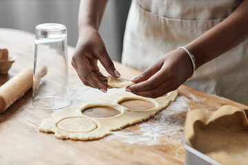Young black woman baking homemade pastry and cutting cookie shapes