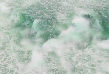 Fototapeta na wymiar Captivating Green Waves with Frothy Sea