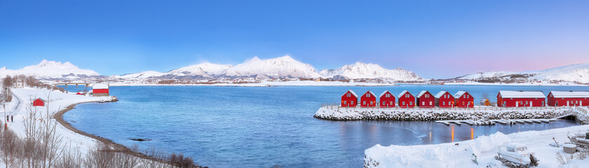 Breathtaking scenery wit traditional red wooden houses on the shore of Offersoystraumen fjord.