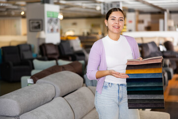 Furniture saleswoman offering material choice in furniture store