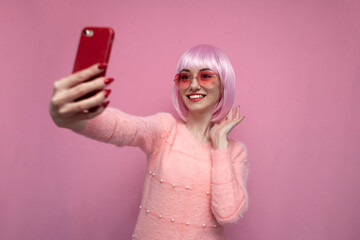girl with pink hair takes a selfie on a smartphone, a woman with a short colored haircut takes a photo of herself