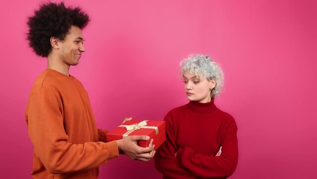 Portrait of upset African American guy looking depressed after painful breakup. Portrait of blonde-haired woman slapping a man. High quality 4k footage