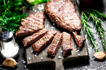 Steak grill on a cutting board with rosemary. 