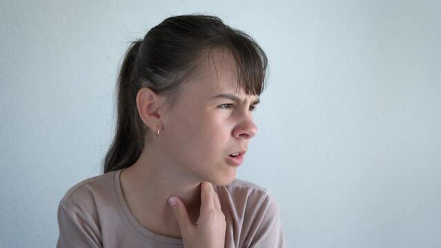 A teenager with a sore throat. A teenage girl suffers from a sore throat.