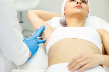armpit botox procedure in cosmetology clinic, woman patient makes armpit botox injection