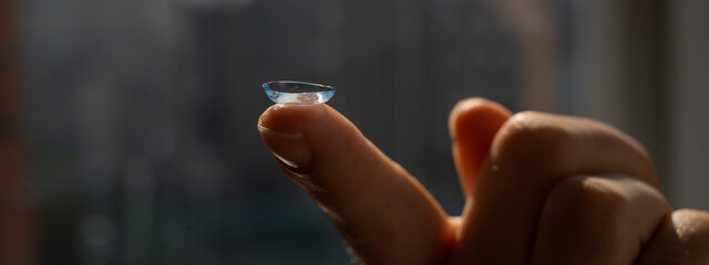 Close-up of a contact lens on a woman's index finger. 