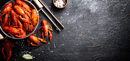 Boiled crayfish in a colander on a stone board. 
