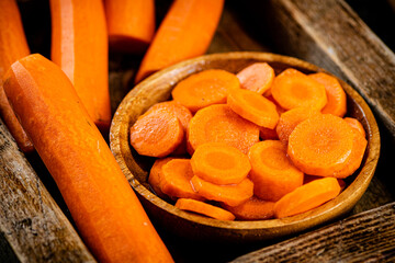 Sliced fresh carrots. On a wooden background.